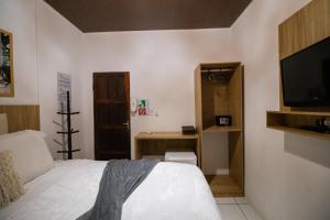 a bedroom with a bed and a flat screen tv at Pousada da Leide in Fernando de Noronha