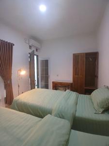 a bedroom with two beds and a dresser at Omah Barepan Temple View in Borobudur
