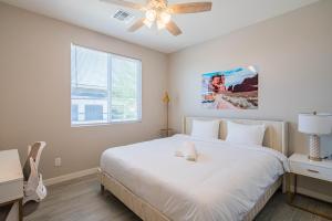 a bedroom with a white bed and a ceiling fan at Serene 2BR Home with Premium Beds in Glendale