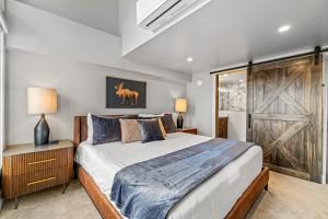 a bedroom with a large bed and a wooden door at Bear Claw 402 - Premier Ski-in Ski-out & Winter Shuttle! Renovated 2025! in Steamboat Springs