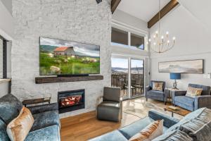 a living room with a stone wall and a fireplace at Bear Claw 402 - Premier Ski-in Ski-out & Winter Shuttle! Renovated 2025! in Steamboat Springs