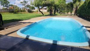 a large blue swimming pool in a yard at Sitiolosbragas in Caetanópolis +21 photos