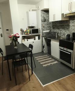 eine Küche mit einem Tisch und einem Tisch und Stühlen in der Unterkunft Chambre simple à 20 minutes de Paris in Livry-Gargan