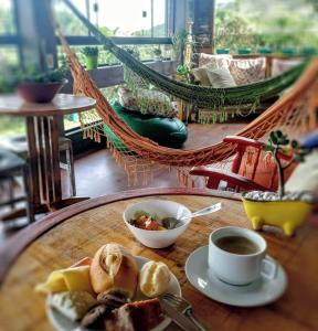 een tafel met een bord eten en een kopje koffie bij Joaquina 433 - Pousada Floripa in Florianópolis