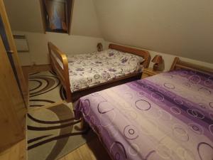 2 posti letto in una piccola camera con lenzuola viola di Vlasic Relax a Vlasic