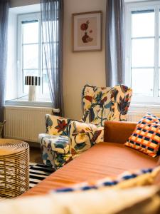 a living room with a couch and a chair and windows at Boží Dar 95 in Boží Dar