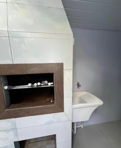 a bathroom with a sink and a bath tub at Casa no Centrinho para 2 pessoas 100m do Mar in Bombinhas +15 photos
