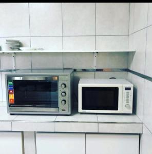eine Mikrowelle und ein Toaster auf einer Küchentheke in der Unterkunft Quinta Altos del Prado in San Nicolás de los Arroyos + 9 Fotos