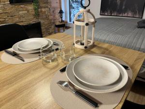 een houten tafel met twee borden en glazen erop bij Studio Chalet des pistes in Gérardmer +2 foto's