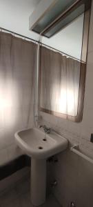 een badkamer met een witte wastafel en een spiegel bij Hotel Thayer in Santiago