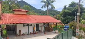 a small house with a red roof at Rio Sereno Suítes Comfort - Lumiar in Lumiar