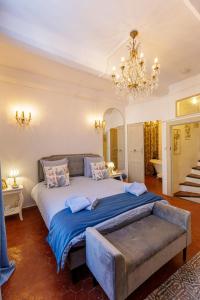 a large bedroom with a large bed and a chandelier at L'escalier gaucher in Lambesc