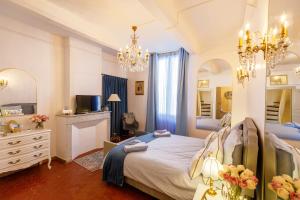 a bedroom with a large bed and a chandelier at L'escalier gaucher in Lambesc