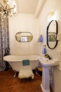 a bathroom with a tub and a sink and a mirror at L'escalier gaucher in Lambesc