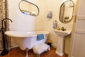 a bathroom with a tub and a sink and a mirror at L'escalier gaucher in Lambesc +33 photos