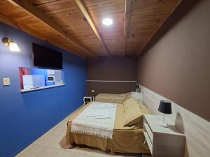 een slaapkamer met een bed en een blauwe muur bij MarinaBella Habitación 5 in Rada Tilly