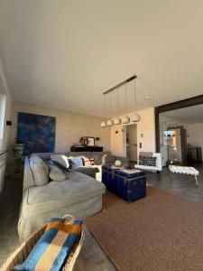 een woonkamer met een bank en een tafel bij Eifeeloft - Eifel erleben in Neroth