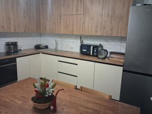 a kitchen with white cabinets and a potted plant on a table at Майдан house in Maidan Village