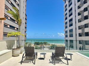 a patio with chairs and a view of the ocean at BEACH CLASS EXECUTIVE apto 206 in Recife