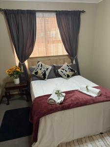 een slaapkamer met een bed met twee handdoeken erop bij Waaigras in Brackenfell +5 foto's