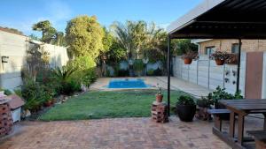 a backyard with a swimming pool in a yard at Waaigras in Brackenfell