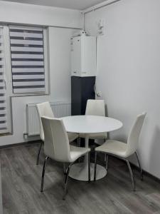 een kamer met een tafel en stoelen en een koelkast bij LuRo Loft Otopeni in Otopeni