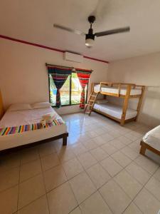 een slaapkamer met twee bedden en een plafondventilator bij Hostal Casa Bohemia in Mérida