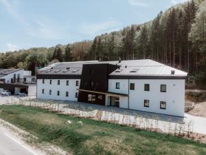 an aerial view of a white building with a black roof at Das Naturlich - Ruhiges Apartment Hotel nahe Regensburg in Sinzing
