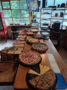 een lange houten tafel met veel pizza's erop bij Cabañas Santa Maria Pucon in Pucón
