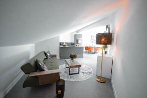 a living room with a couch and a table at Das Naturlich - Ruhiges Apartment Hotel nahe Regensburg in Sinzing