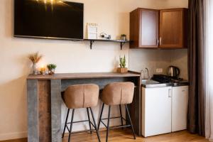 a kitchen with a counter and two stools at a bar at Podgorica City Center Apartment Main Boulevard View Free Wi-Fi in Podgorica +18 photos