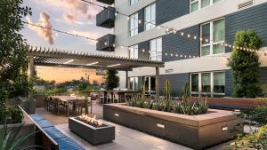 an outdoor patio with tables and chairs and a building at Landing Chic 2BD Gym Clubhouse in Tempe