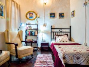 una camera da letto con un letto e una sedia di Aloe Apartament 2 plus 1 gratis w Casa Verde de Guía a Santa Maria de Guia