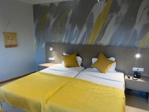 - une chambre dotée d'un grand lit avec des draps jaunes dans l'établissement BE ONE HOTEL Caldas da Rainha - by MHMB Hospitality, à Caldas da Rainha