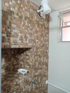 a brick wall in a bathroom with a dog toy at Suites Helena in Ilhabela