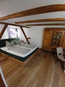 een slaapkamer met een bed in een kamer met houten vloeren bij bei GRETA Wohnung 77 in Marl