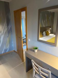 Cette chambre comprend un bureau avec un miroir et un lit. dans l'établissement BE ONE HOTEL Caldas da Rainha - by MHMB Hospitality, à Caldas da Rainha