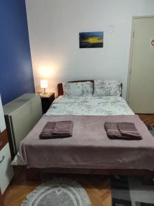 een slaapkamer met een bed met twee handdoeken erop bij KS Studio in Borča