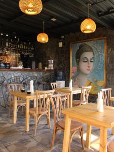 un ristorante con tavoli di legno e un ritratto di una donna di Hotel Onsen a Guatapé