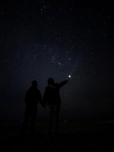 a man and woman standing under a starry sky at Hayaat siwa hot spring in Siwa