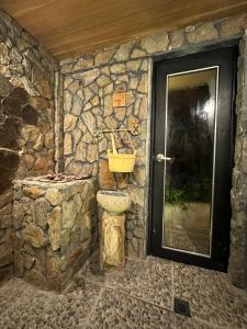 un bagno in pietra con lavandino e porta di Hotel Onsen a Guatapé