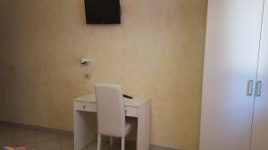 a white desk with a chair and a television on a wall at Hotel Villa Etrusca in Marina di Campo