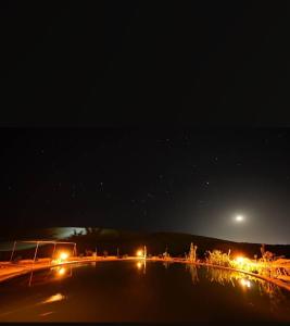 a street at night with the moon in the sky at Hayaat siwa hot spring in Siwa