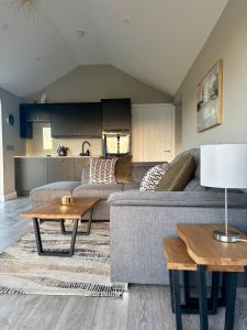 een woonkamer met een bank en een tafel bij Beyond The Waters Edge Chalet in Dooagh