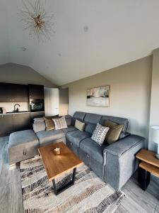 een woonkamer met een bank en een tafel bij Beyond The Waters Edge Chalet in Dooagh