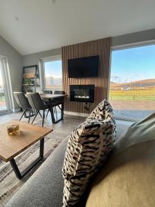 een woonkamer met een bank, een tafel en een televisie bij Beyond The Waters Edge Chalet in Dooagh