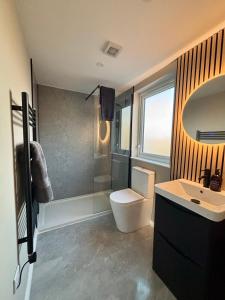 een badkamer met toilet en wastafel bij Beyond The Waters Edge Chalet in Dooagh