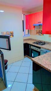 a kitchen with red and white cabinets and blue tile floors at le riffe in Nador