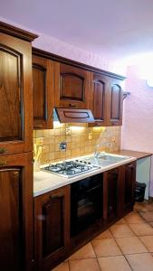 eine Küche mit Holzschränken und einem Herd mit Backofen in der Unterkunft La Tavernetta in Ponte della Venturina
