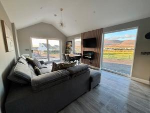 een woonkamer met een bank en een tafel bij Beyond The Waters Edge Chalet in Dooagh +5 foto's